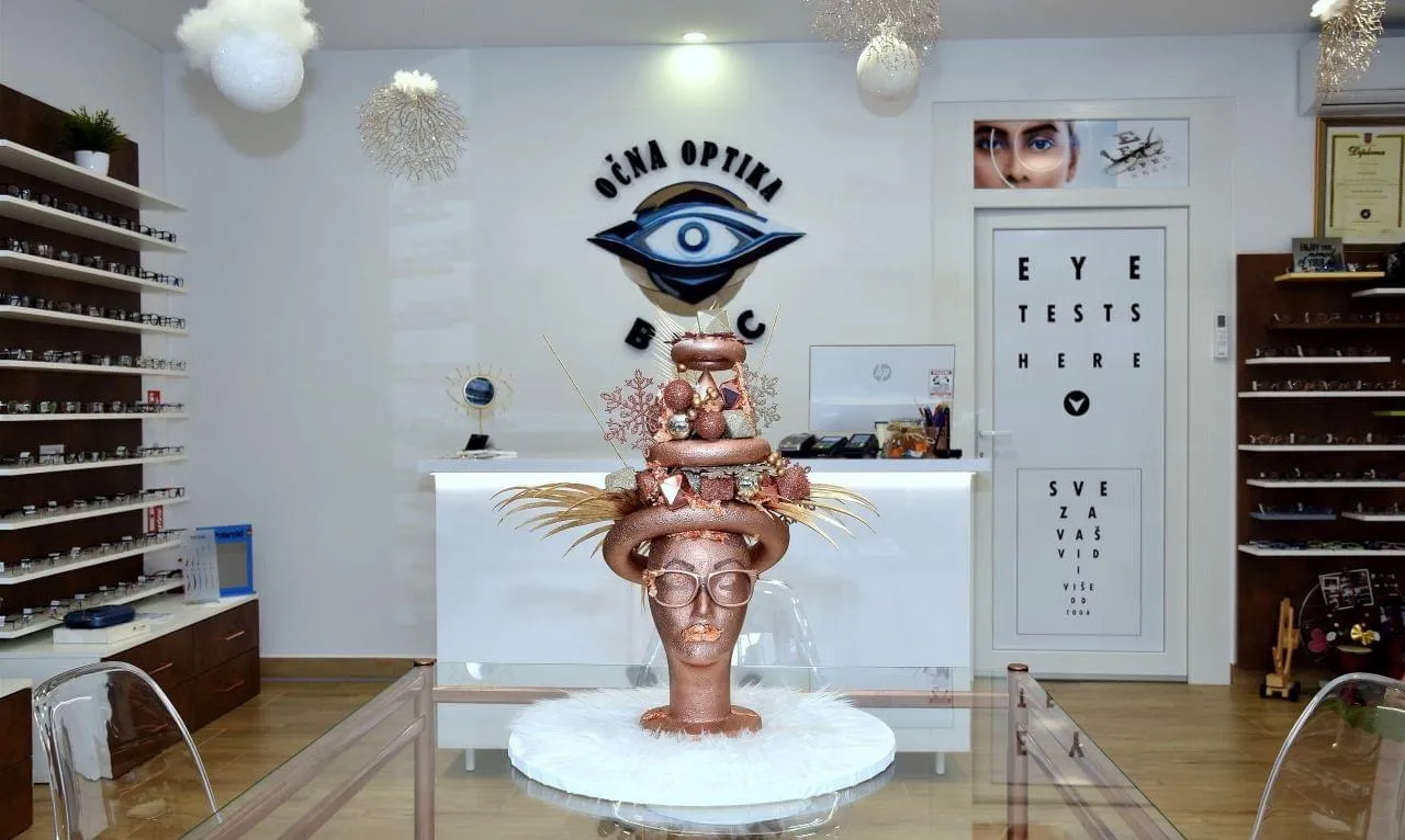Interijer optike: logo na zidu, pult i vrata s natpisom Eye Tests Here